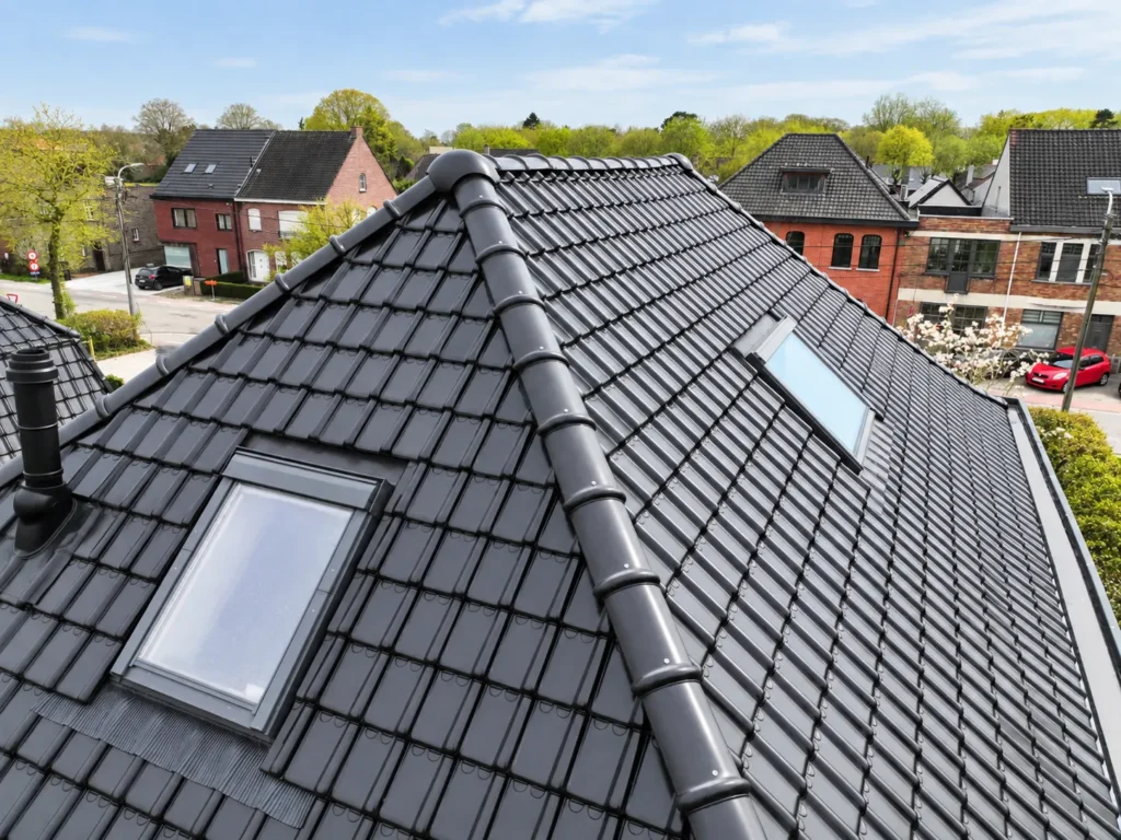 Dakrenovatie De Pinte: dakramen netjes ingewerkt tussen de donkere dakpannen